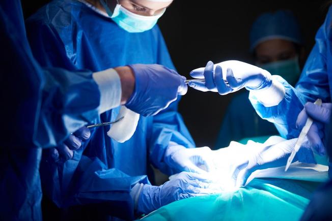 Desktop surgeons working in dark operating theatre